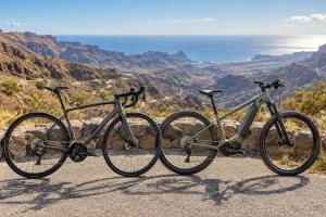 A road bike and an electric mountain bike above a dry ravine with the Atlantic in the distance